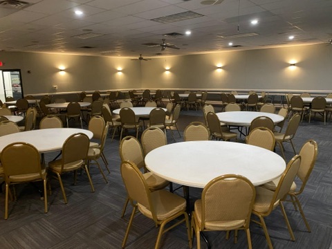 Wide angle of the banquet hall with a dance floor and ambient lighting.